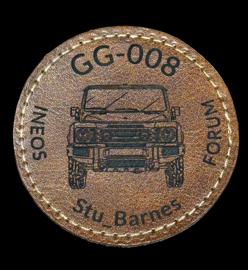A circular brown iron on badge with text and a graphic representing the INEOS Grenadiers community. The badge features a vehicle and includes personalized membership number and username.